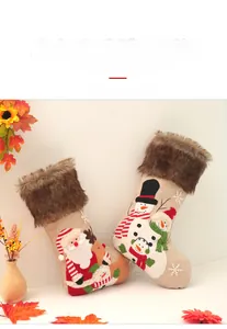 Detailed view of linen Christmas stockings with plush trim and embroidered Santa and Snowman