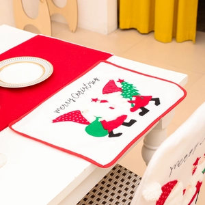 Christmas table mat and chair cover set with gnome embroidery on white wooden table