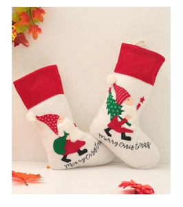 Detailed close-up of embroidered gnome Christmas stockings with merry christmas text