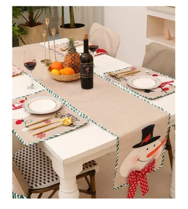 Detailed view of linen Christmas table runner and placemats with snowman embroidery