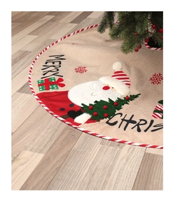 Detail of burlap Christmas tree skirt featuring rustic Santa Claus and festive Merry Christmas text