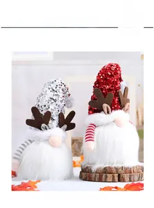 Detalle de gnomos de Navidad con lentejuelas y astas de reno sobre base de madera