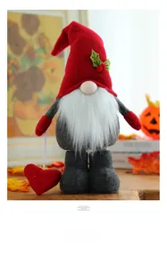 Detailed plush Christmas gnome holding a red heart with winter holly on its hat