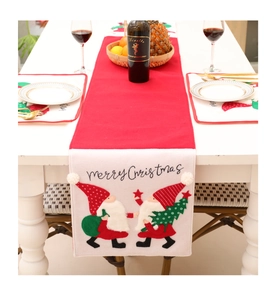Detail showing red Christmas table runner with gnome embroidery and Merry Christmas text