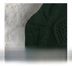 Nahaufnahme der dunkelgrünen Strickstruktur eines Plüsch-Weihnachtsstrumpfs für die Deko