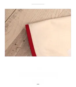 Gros plan du tapis de sapin de Noël en feutre beige avec bord cousu rouge et doux