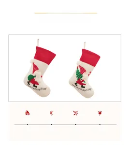 Detail of embroidered plush Christmas stockings with Santa Claus and gnome designs