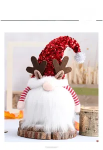 Detalle de gnomo navideño con gorro de lentejuelas rojas, astas de reno y barba blanca