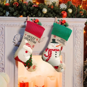 Weihnachtssocken aus Leinen mit Weihnachtsmann und Schneemann am Kamin aufgehängt