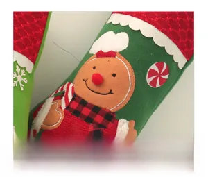 Detail of green Christmas stocking with gingerbread man embroidery and peppermint candy