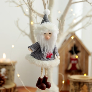 Handgefertigter Weihnachtsgnom mit grauem Strickoutfit und Stern am weißen Baumzweig