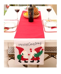 Detail of red and cream Christmas table runner with Merry Christmas embroidery and pom-poms