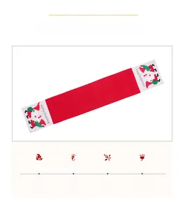 Detail of red Christmas table runner featuring embroidered Santa and Merry Christmas text