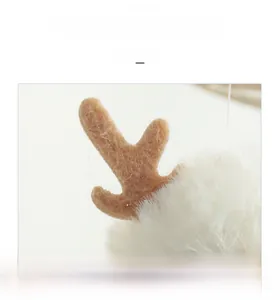 Detailed macro view of soft white plush fabric and brown felt reindeer antlers ornament