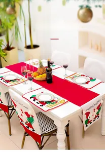 Detailed view of red Christmas table runner with embroidered Santa and matching placemats