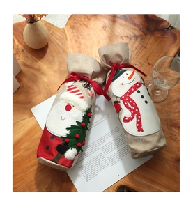 Detail of burlap Christmas wine bottle covers with Santa Claus and Snowman embroidery