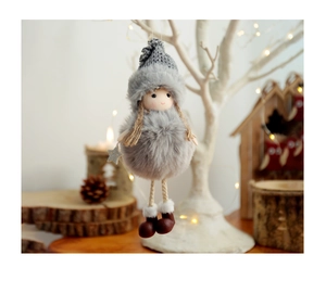 Close-up of plush angel ornament with knitted hat and silver star on a festive tree