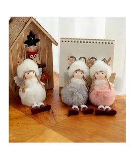 Three plush Christmas angel reindeer ornaments in white, grey and pink on a wooden desk