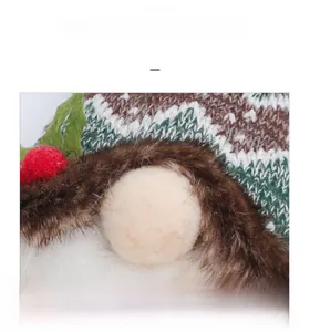 Detail of green and white knitted Christmas gnome hat with soft brown faux fur texture