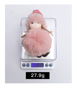 Pink plush angel Christmas ornament on digital scale weighing 27.9 grams
