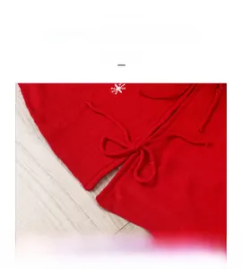 Dettaglio della gonna per albero di Natale in maglia rossa con fiocchi di neve