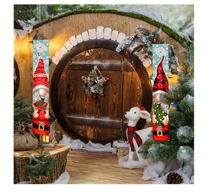 Striscioni per porte con gnomi di Natale appesi a una porta rotonda in legno con decori