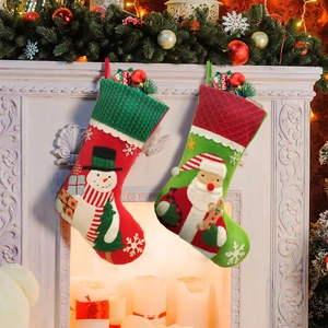 Large embroidered Christmas stockings set with Santa and Snowman hanging on a white fireplace