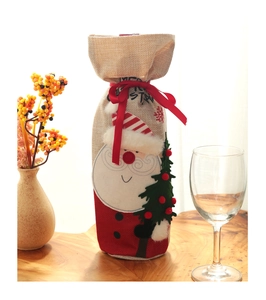 Detailed view of linen Christmas wine bottle cover with Santa and tree embroidery