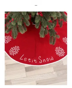 Close-up of red knitted Christmas tree skirt featuring Let it Snow text and snowflakes