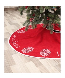 Close-up of red knit Christmas tree skirt featuring white snowflakes and Let it snow text