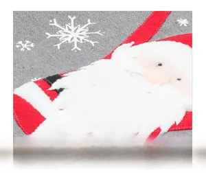 Detailaufnahme des Weihnachts-Tischläufers aus Leinen mit Weihnachtsmann-Stickerei und Flocken
