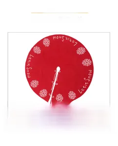 Close-up of red knit Christmas tree skirt with white snowflake and Let it Snow embroidery