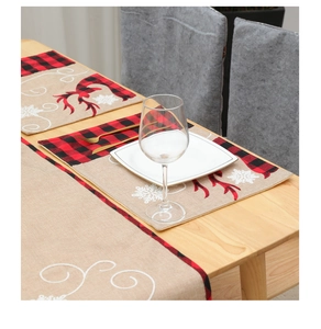 Close-up of burlap Christmas table runner with reindeer antlers and red buffalo plaid edges