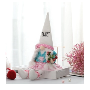 Detail of a Valentine gnome doll with sweet embroidery sitting on a white book decor