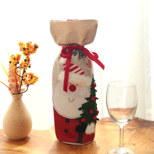 Christmas burlap wine bottle cover featuring embroidered Santa Claus with a festive red ribbon