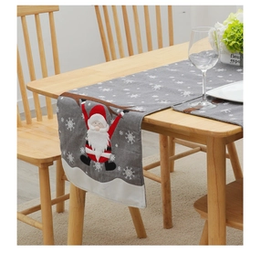 Detailed embroidery of Santa Claus and white snowflakes on gray linen Christmas table runner