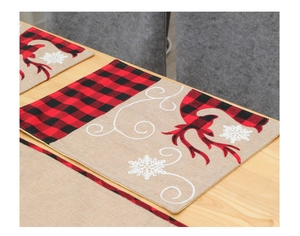 Detailed view of burlap Christmas place mat with reindeer silhouette and red plaid edge