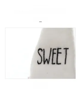 Detail view of the white knitted hat featuring the black SWEET embroidery and fabric texture