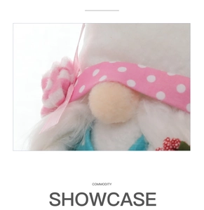 Close-up of fluffy white plush gnome with pink polka dot ribbon and fabric flower decor