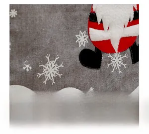 Close-up of burlap texture with white snowflake embroidery and Santa Claus patch on a table runner