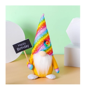 Detail of a plush birthday gnome with rainbow hat and Happy Birthday sign accessory