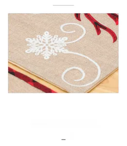 Close-up of beige linen Christmas table runner showing white snowflake embroidery detail