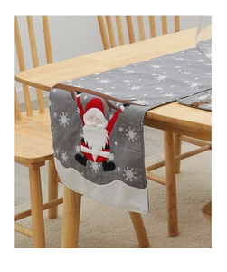 Detail of grey burlap table runner with Santa Claus embroidery and white snowflake prints