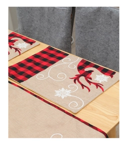 Detailed view of linen Christmas table runner with red buffalo plaid reindeer and snowflakes