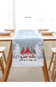 Détail d'un chemin de table bleu clair avec motifs de gnomes de Noël et de flocons de neige