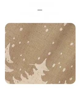 Close-up detail of light brown chair cover fabric with white pine and snowflake prints