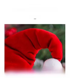 Detailed close-up of red velvet Christmas doll hat with white plush pom-pom and soft texture