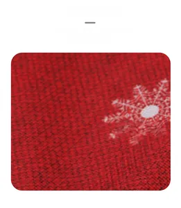 Close-up detail of red Christmas table runner with white snowflake patterns on woven fabric