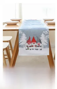 Détail d'un chemin de table de Noël bleu avec motifs de nains et de flocons de neige