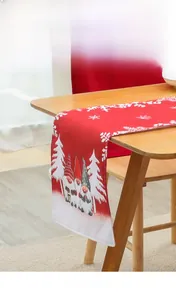 Close-up of festive red Christmas table runner with gnomes and white snowflake patterns